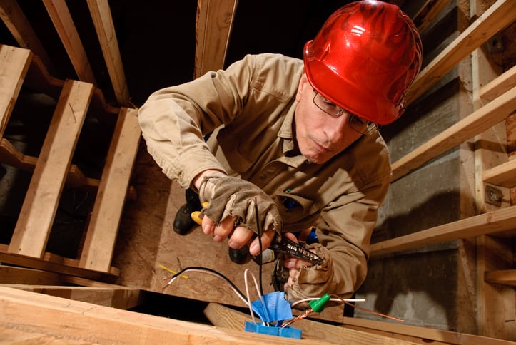 Palmetto Electrical Contractors | electrician wiring a junction box in a building under construction