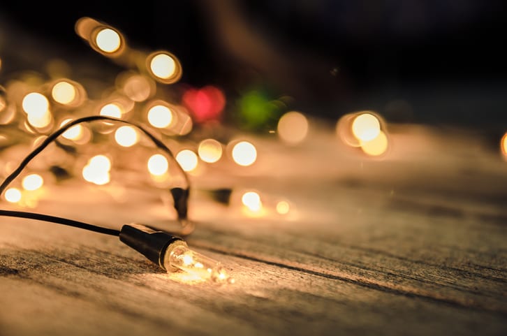 Palmetto Electrical Contractors | Christmas lights laying on a wooden background lit up at night